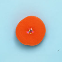 Bright orange beret with floral details