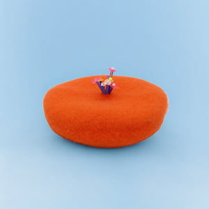 Bright orange beret with floral details